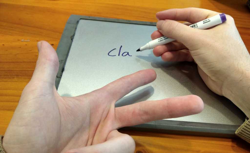 Example of a student using the finger spelling statergy while spelling on a whiteboard.